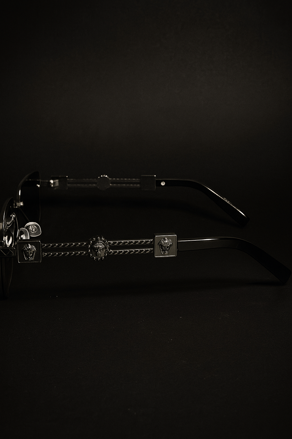 Black eyeglasses with decorative arm details on a black background