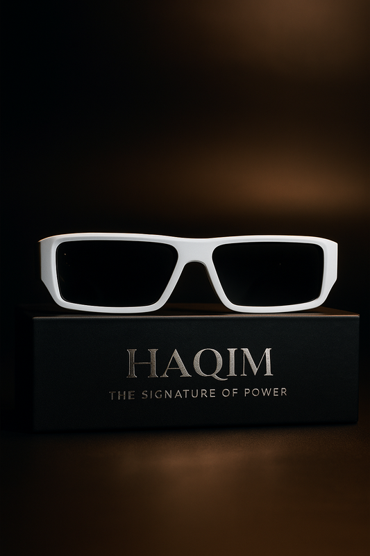 White sunglasses on a black box with 'HAQIM' branding against a dark background