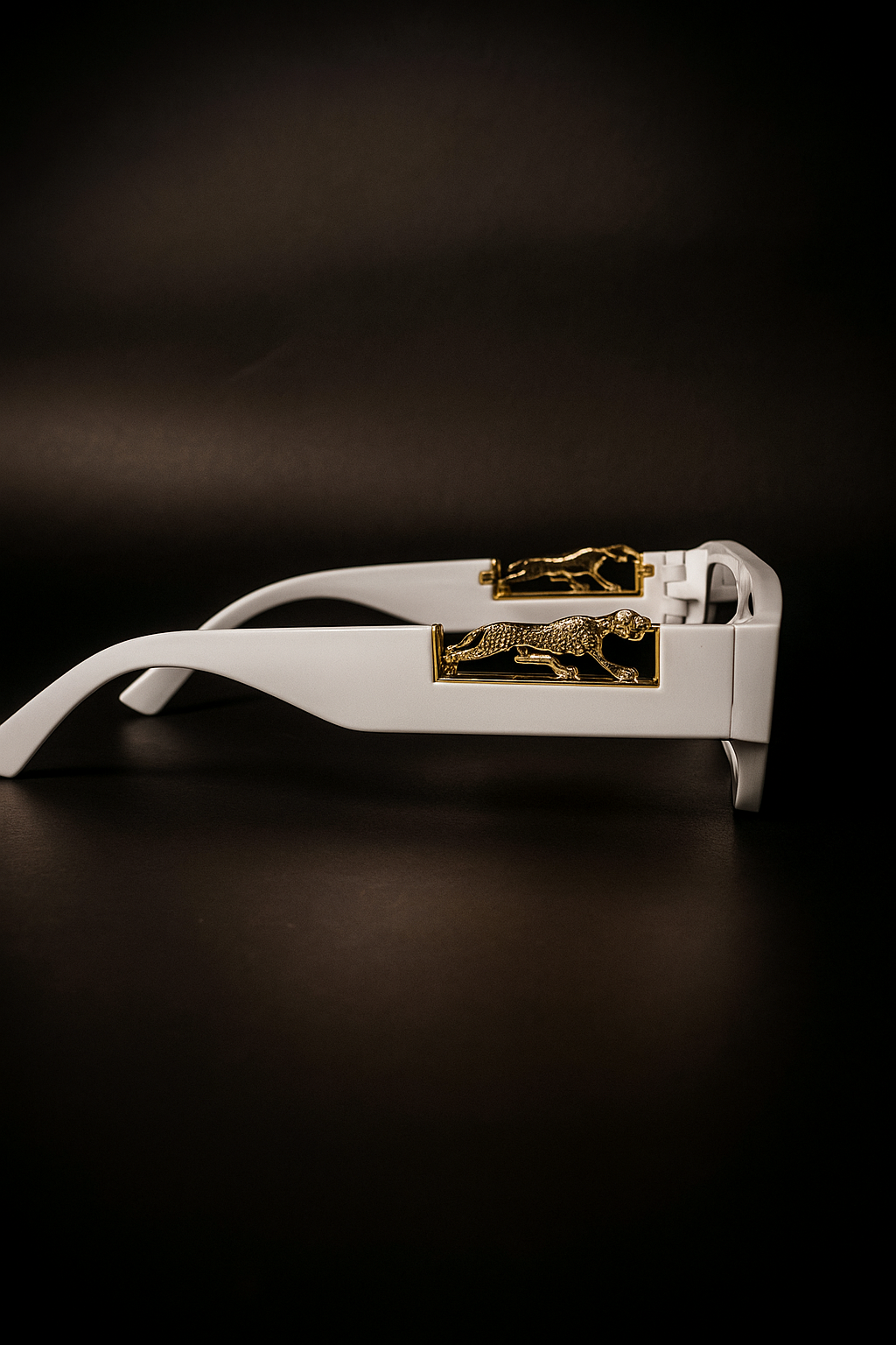 White eyeglasses with gold accents on a dark background